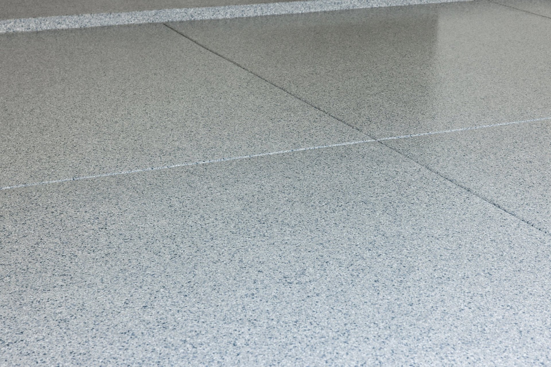 Close-up of a polished concrete floor with grout lines and a clean, light gray speckled surface