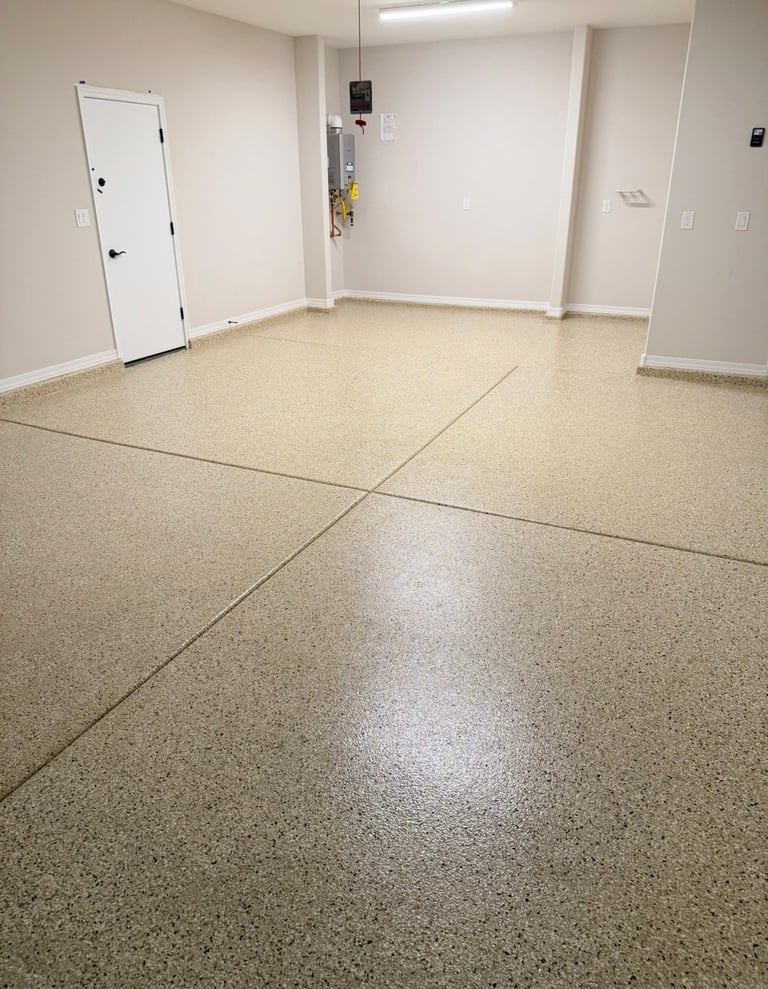 Empty commercial space with light beige speckled flooring, white walls, fluorescent ceiling light, white door on left, and electrical outlets