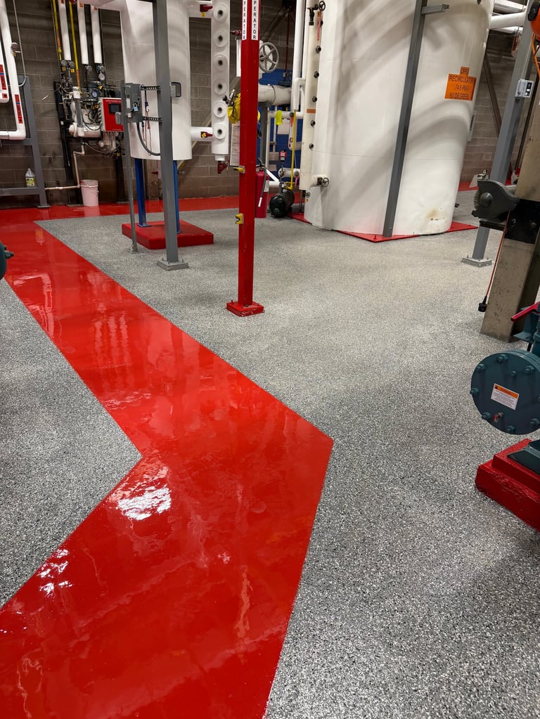 Industrial garage with red directional floor markings, lift equipment, and gray epoxy flooring
