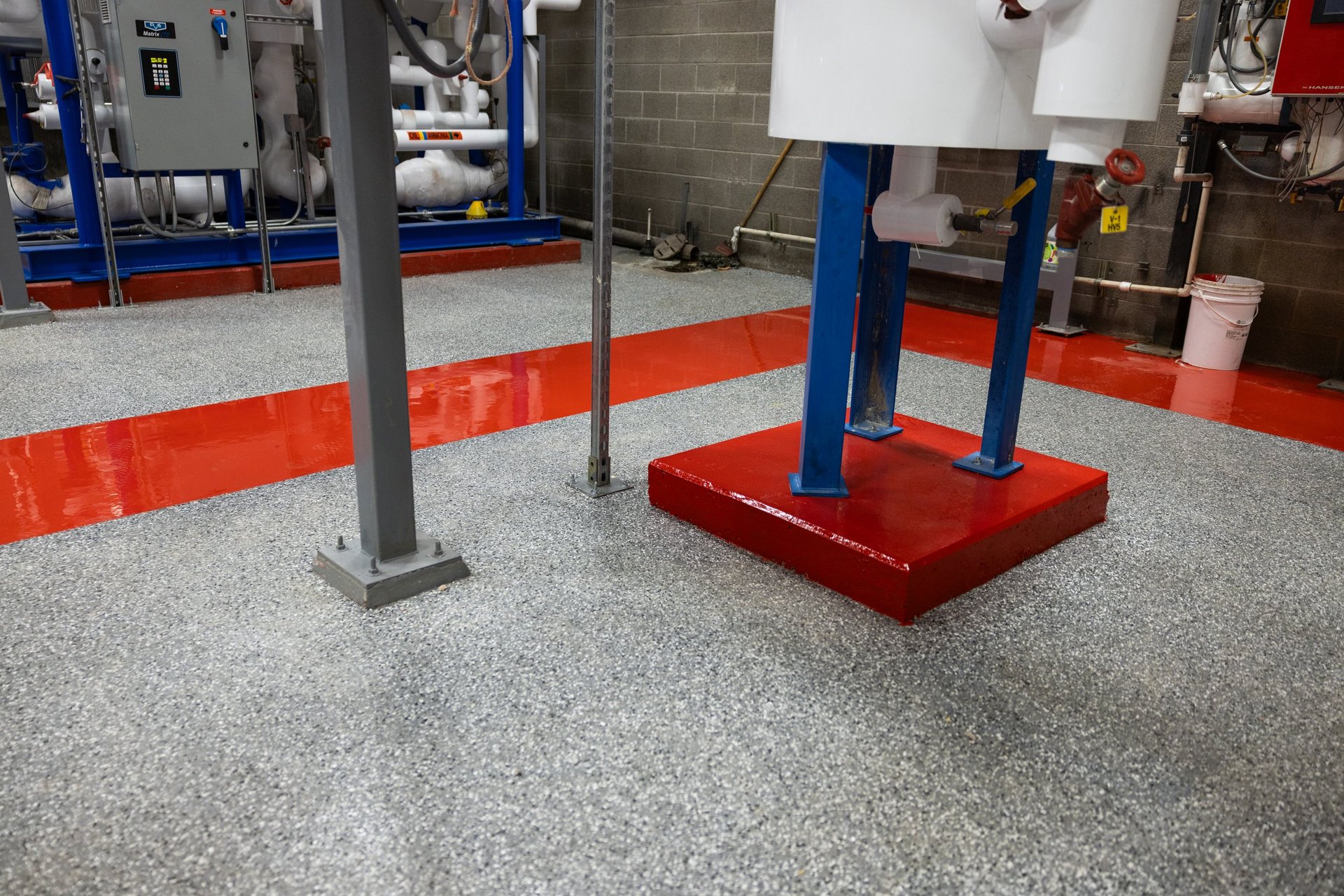 Garage workshop with gray epoxy floor, orange stripe, blue lift columns, and red platform for vehicle maintenance equipment