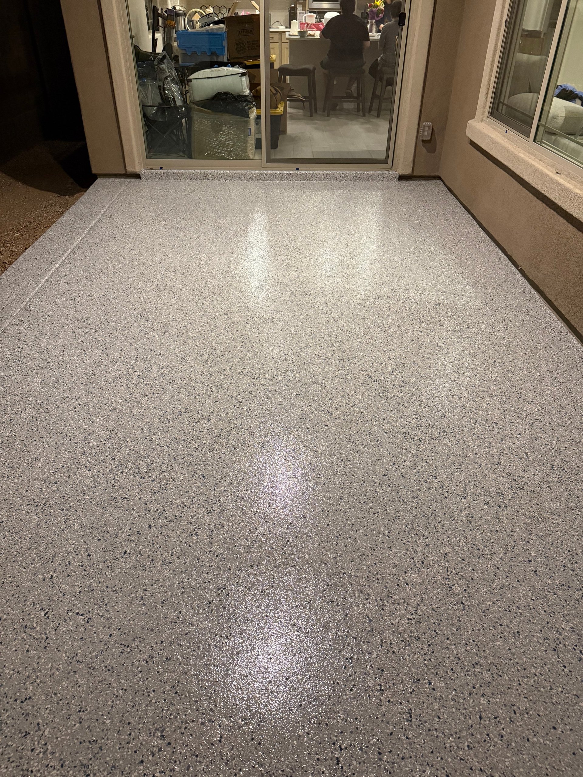 Polished concrete entryway floor with glass doors leading into a home interior